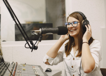 Female host communicating on Microphone. Woman in radio studio.